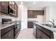 Modern kitchen featuring stainless steel appliances, dark wood cabinets, and granite countertops at 4148 Lavender Ct, Lake Hamilton, FL 33851