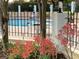 Community pool with red flowering plants in the foreground and lounge chairs at 443 Hamptoncrest Cir # 103, Lake Mary, FL 32746