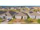 An aerial view of a home with solar panels, a driveway, a garage and landscaping in a residential community at 473 Disa Dr, Davenport, FL 33837