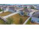 Aerial view of fenced backyard, screened porch, solar panels, and nearby homes at 473 Disa Dr, Davenport, FL 33837