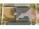 An aerial view showcasing the home's roof, solar panels, and fenced backyard at 473 Disa Dr, Davenport, FL 33837