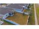 Aerial view of a fenced backyard with a screened porch, solar panels, and a storage shed at 473 Disa Dr, Davenport, FL 33837