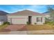 Charming single-story home with a paved driveway and attached garage at 473 Disa Dr, Davenport, FL 33837