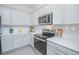 Bright, spacious kitchen with white shaker cabinets, stainless steel appliances, and quartz countertops at 473 Disa Dr, Davenport, FL 33837