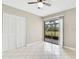 Bedroom with a sliding glass door leading to a patio, tiled flooring, and closet doors at 6030 Village Cir, Orlando, FL 32822
