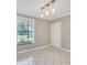Empty room with tiled flooring, window, closet, and a unique light fixture at 6030 Village Cir, Orlando, FL 32822