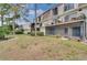 View of the condo building's exterior with balconies and a screened patio from a grassy common area at 6030 Village Cir, Orlando, FL 32822