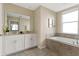 Elegant bathroom with double vanity, soaking tub, and tiled flooring at 781 Ocean Course Ave # 601, Davenport, FL 33896