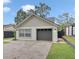 Front exterior view of home with gray garage door, brick driveway, and landscaping at 1517 E Esther St, Orlando, FL 32806