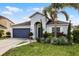 Inviting one-story home with navy blue garage, palm tree, and landscaped yard at 2213 Grantham Ave, Davenport, FL 33837
