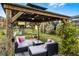 Covered gazebo with seating area, swing set, and lush landscaping at 2213 Grantham Ave, Davenport, FL 33837