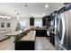 A view of the kitchen's granite island, dark wood cabinetry, and stainless steel appliances at 2213 Grantham Ave, Davenport, FL 33837