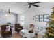 Living room with a Christmas tree, sectional, geometric accent wall, and dining area at 2213 Grantham Ave, Davenport, FL 33837
