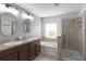 Main bathroom featuring dual vanities, soaking tub, glass shower, and tile floors at 2213 Grantham Ave, Davenport, FL 33837