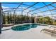 Inviting pool with a waterfall feature, screened enclosure, and ample patio space at 2213 Grantham Ave, Davenport, FL 33837