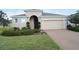 One-story house with beige exterior, two-car garage, and manicured lawn at 2393 Jernigan Loop, Kissimmee, FL 34746