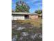Large backyard with unkempt grass and a brick house at 2680 Palmetto Rd, Mount Dora, FL 32757
