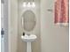 A clean, modern bathroom with pedestal sink and oval mirror at 3780 Plainview Dr, Orlando, FL 32824