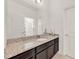 Bathroom with granite countertop, dark brown vanity, and tiled floor at 488 Sapphire Dr, Davenport, FL 33837