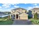 Two-story house with a three-car garage, and a brick driveway at 488 Sapphire Dr, Davenport, FL 33837