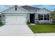 One-story home with gray siding, white garage door, and red shutters at 811 Turner Ln, Winter Haven, FL 33881