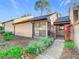 Tan stucco house with dark gray roof, walkway, landscaping, and trees at 940 Douglas Ave # 217, Altamonte Springs, FL 32714