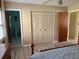 Bedroom with wood-look floors, large closet, and access to bathroom at 11 Sandra Cir, New Smyrna Beach, FL 32168