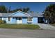 Cute light blue house with gray roof, driveway, and landscaped lawn at 11 Sandra Cir, New Smyrna Beach, FL 32168