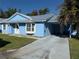 Charming light blue house with gray roof, driveway, and well-maintained lawn at 11 Sandra Cir, New Smyrna Beach, FL 32168