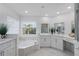 Modern Primary bathroom with double vanity, soaking tub, and marble tile at 2110 Turkey Oak Ct, Oviedo, FL 32766