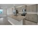 Modern kitchen boasts stainless steel appliances, a large granite island, and ample counter space at 3013 Tackle Dr, Leesburg, FL 34748