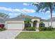 One-story house with a two-car garage and a palm tree at 3528 Chapel Hill Blvd, Clermont, FL 34711