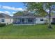 Back of house with screened patio and grassy yard at 3528 Chapel Hill Blvd, Clermont, FL 34711