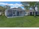 Back of house with screened patio and grassy yard at 3528 Chapel Hill Blvd, Clermont, FL 34711