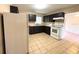 View of kitchen with dark cabinets and white appliances at 5165 Gwynne Ave, Orlando, FL 32810