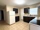 Kitchen with dark cabinets and white appliances at 5165 Gwynne Ave, Orlando, FL 32810