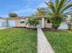 Front exterior of a single-story home with a landscaped yard and palm trees at 7008 Watseka Ave, Orlando, FL 32818