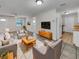Bright living room with tiled floors, comfy seating, and a view into the kitchen at 7008 Watseka Ave, Orlando, FL 32818
