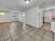 Open living area with tile flooring; view of kitchen and access to other rooms at 7008 Watseka Ave, Orlando, FL 32818