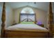 Main bedroom with large wooden bed frame and window at 8100 Fan Palm Way, Kissimmee, FL 34747