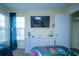 Bedroom with a large TV, dresser, and window with curtains at 8100 Fan Palm Way, Kissimmee, FL 34747