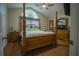 Main bedroom with a large wooden bed frame and hardwood floors at 8100 Fan Palm Way, Kissimmee, FL 34747
