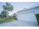White two-car garage with driveway at 8100 Fan Palm Way, Kissimmee, FL 34747