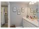 Dual vanity bathroom with white cabinetry and decorative artwork at 9401 La Salle St, Groveland, FL 34736