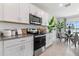 White kitchen with stainless steel appliances, granite countertops, and dining area at 1232 Big Bass Dr, Ormond Beach, FL 32174