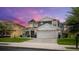 Two-story house with gray siding, a large garage, and a landscaped yard at 2377 Victoria Dr, Davenport, FL 33837