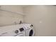 Bright laundry room with washer and dryer, and overhead shelving at 2377 Victoria Dr, Davenport, FL 33837