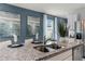 Detail of the kitchen island with a double sink, granite countertop, and modern faucet at 3552 For Mellon Ln, Sanford, FL 32773