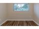 Small bedroom with wood-look floors and a window at 5815 Harrington Dr, Orlando, FL 32808