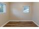 Simple bedroom with wood-look floors and two windows at 5815 Harrington Dr, Orlando, FL 32808